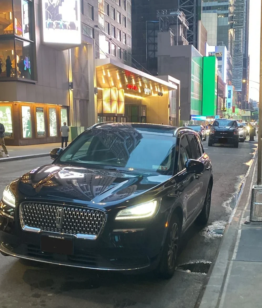 Black sedan parked near sidewalk