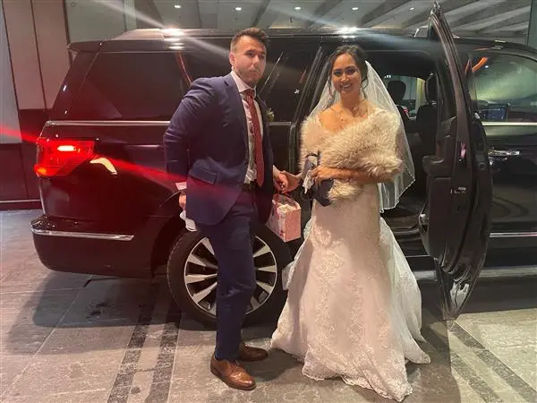 bride and groom in front of SUV