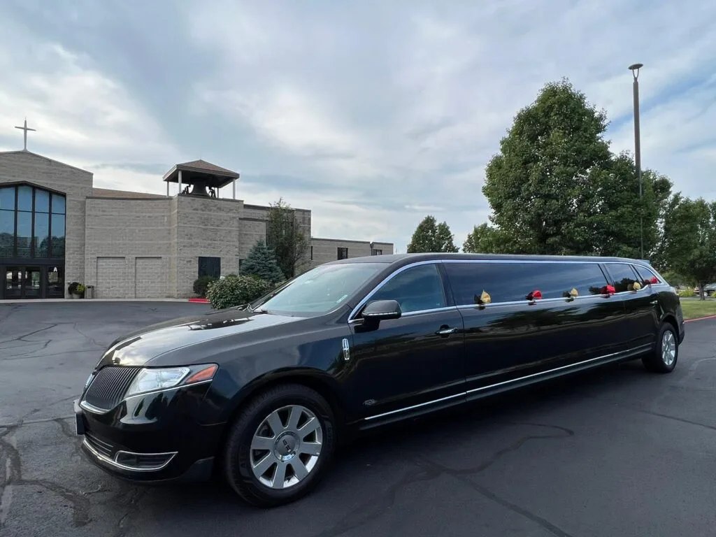 Black limousine parked in front of church
